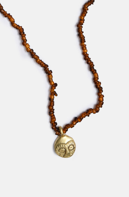 Brown glass necklace with African mask charm